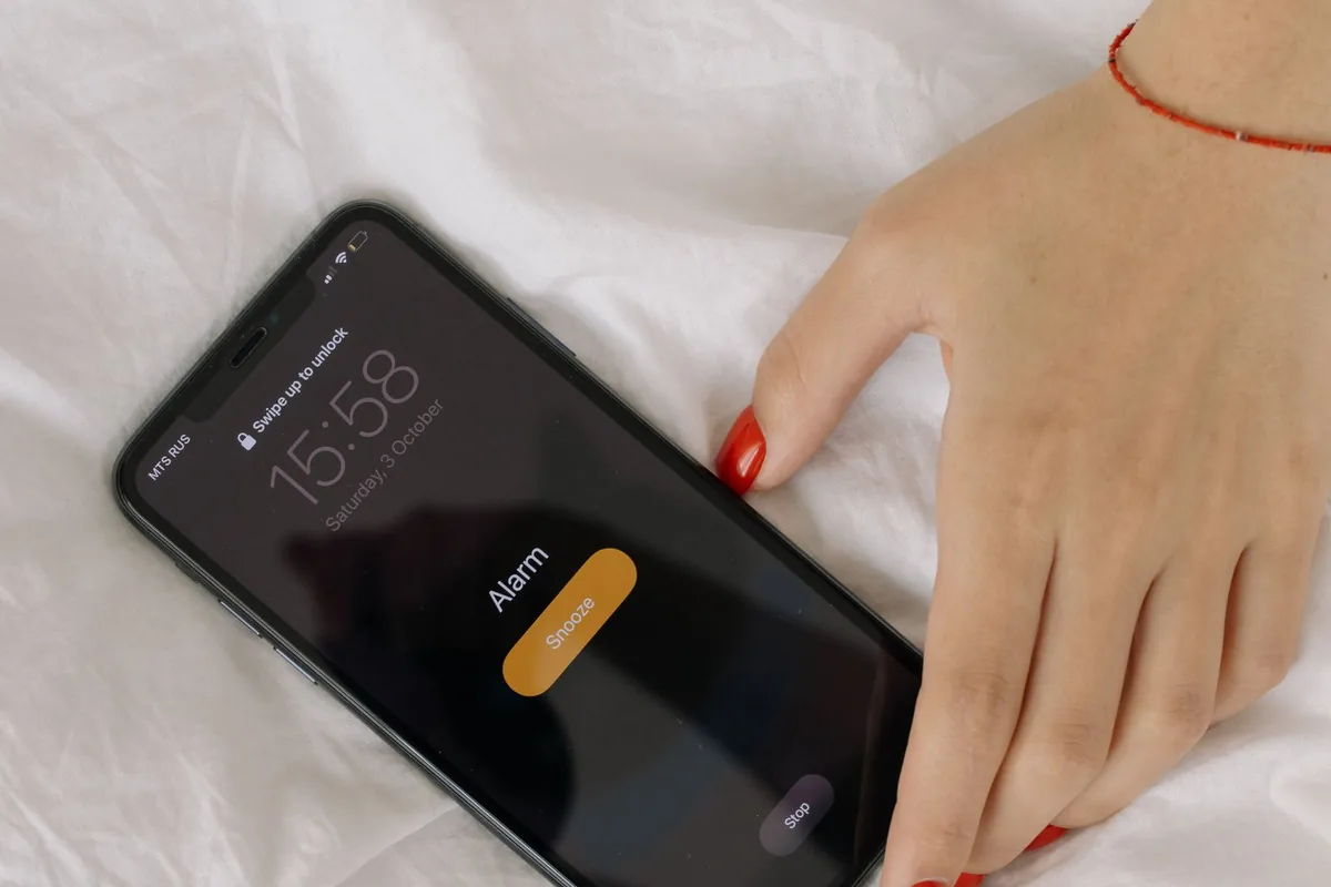 机の上でスマホの通話画面を操作する手元