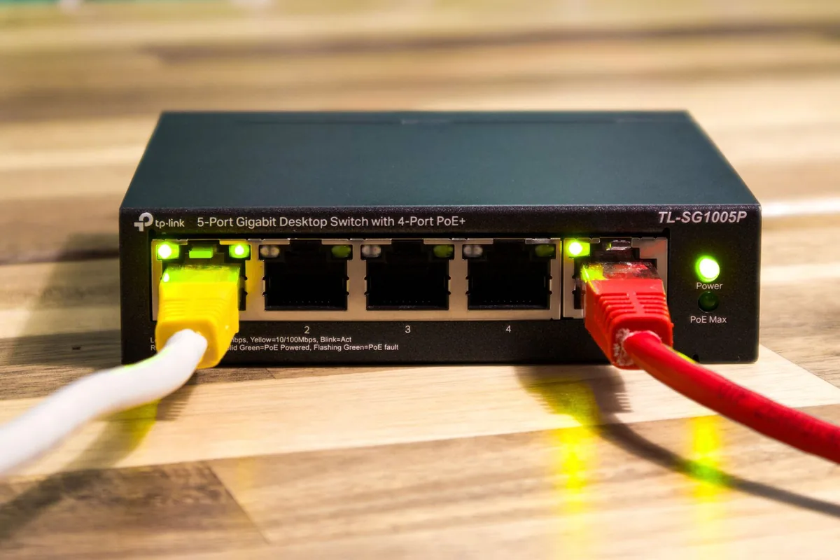 机の上のLANスイッチに差し込まれたケーブル