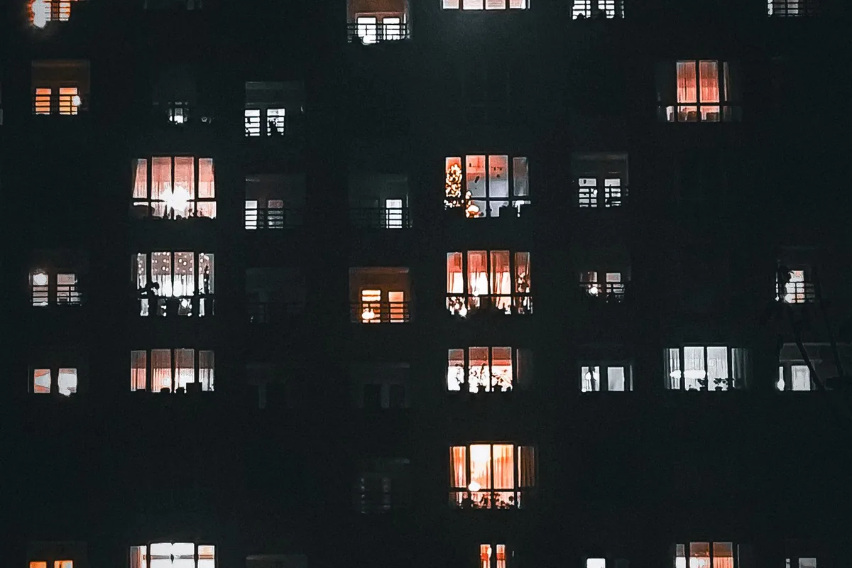 夜に明かりのついたマンションの窓
