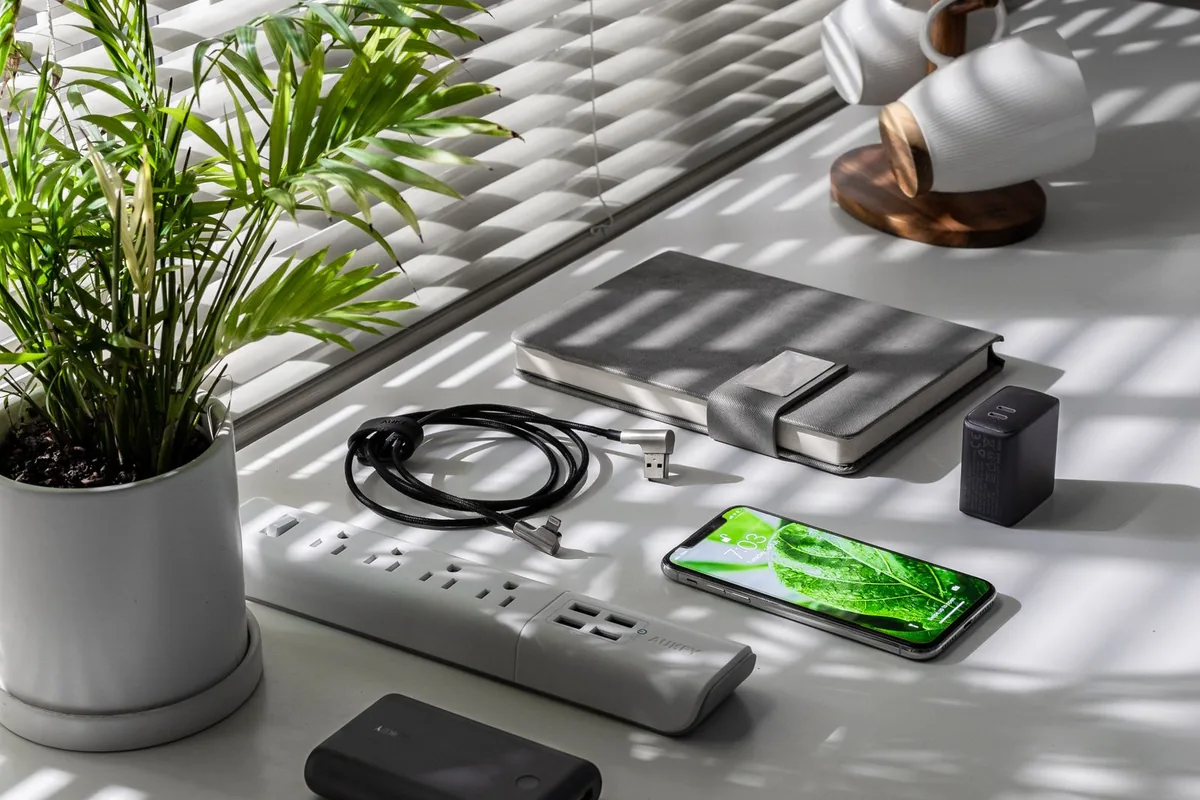 机の上に置かれたWi-Fiルーターと電源タップ、観葉植物