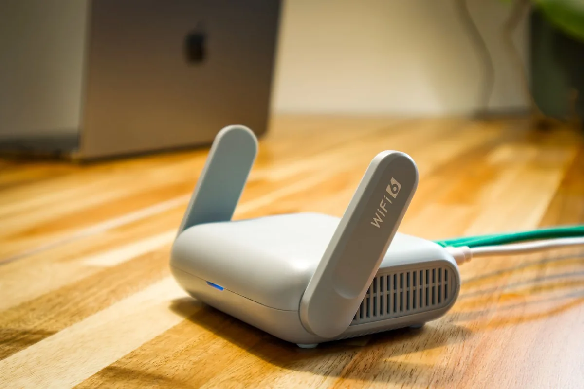 床に置かれたアンテナ付きのWi-Fiルーターと、背面から伸びるLANケーブル