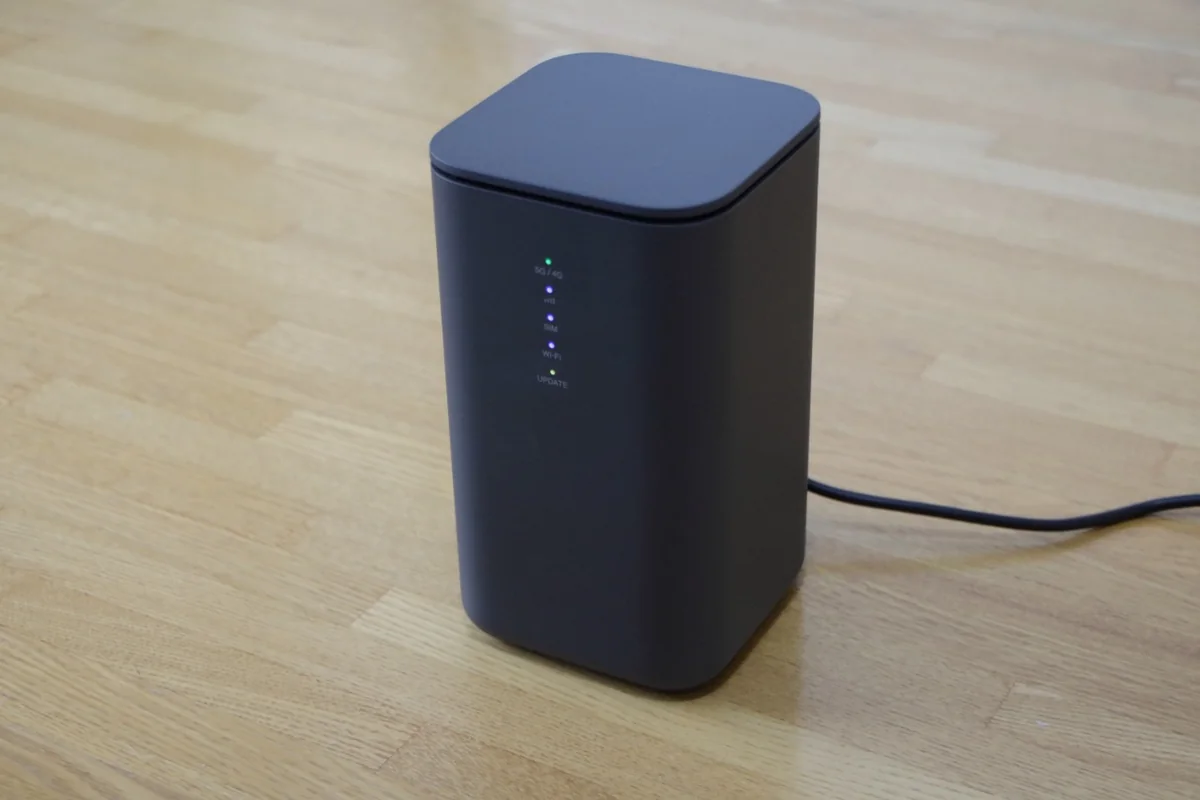 床に置かれた黒いホームルーター。5G/4Gのランプが点灯している