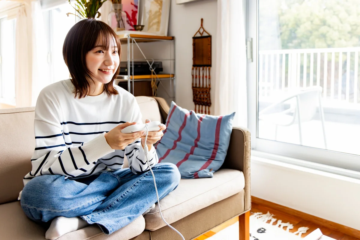 自宅のソファでオンラインゲームをしている様子。通信が切れると対戦が中断される
